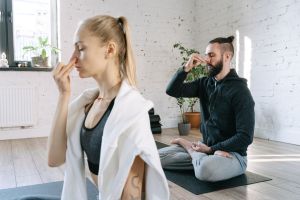 A man and woman practicing mindful yoga and breathing exercises in a serene indo