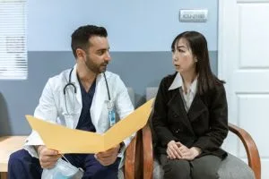 Healthcare professional consults patient in clinical setting. Medical discussion