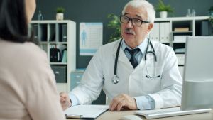Experienced doctor consulting a patient in a medical office setting.